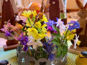 Osterdeko mit kleinen wilden Blüten